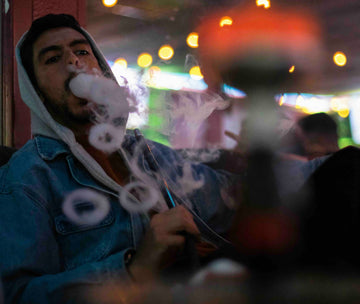 Customer exhaling a cloud of hookah smoke at Empire Hookah Lounge